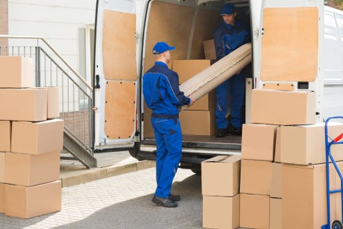 Removal team applying safe lifting procedures during a house move